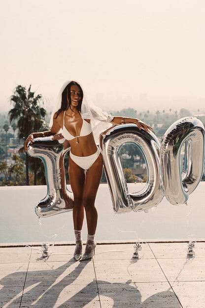 Full-length view of the ivory bikini bottoms showing the drape and movement.